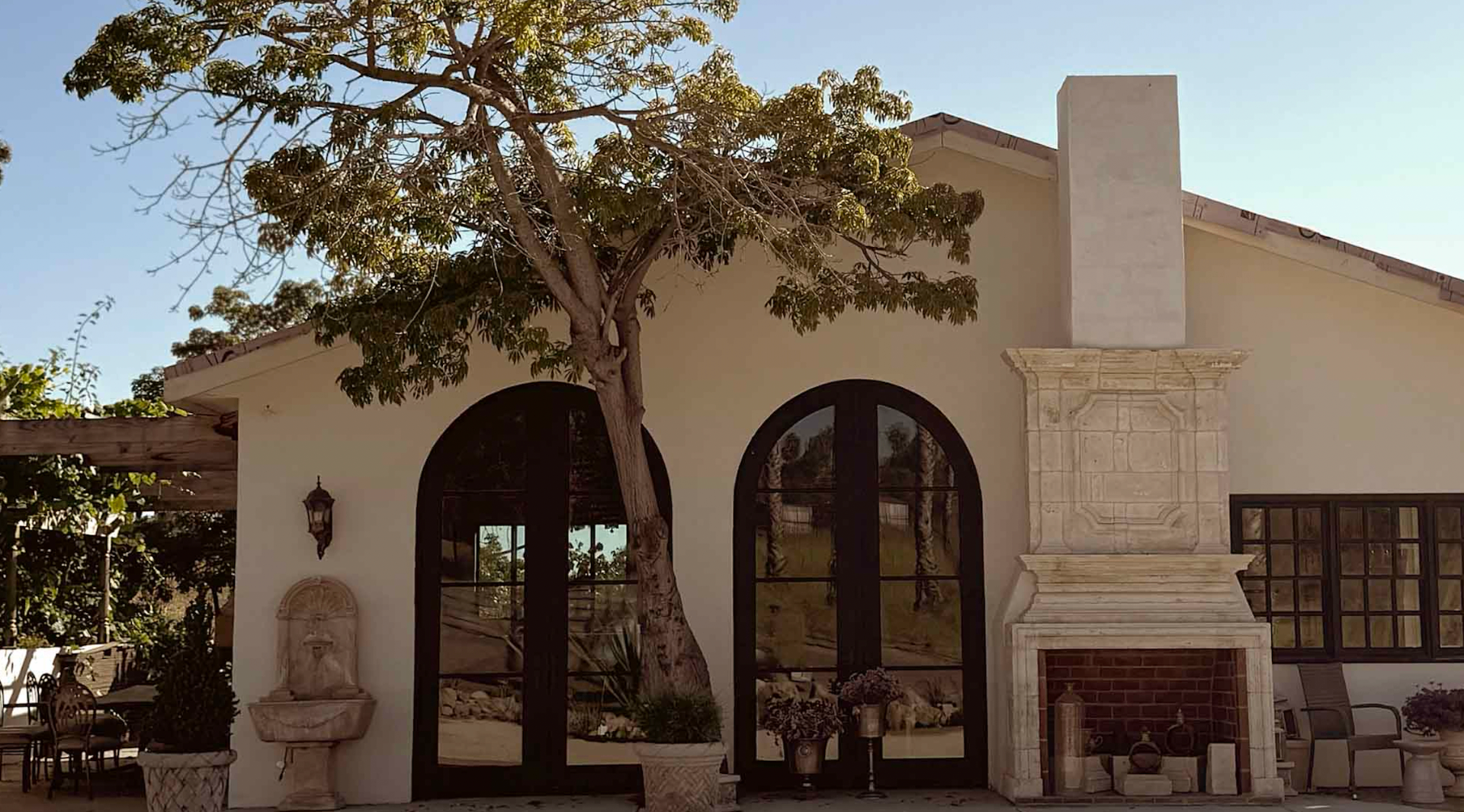 Mediterranean venue exterior with arched doors and stone fireplace